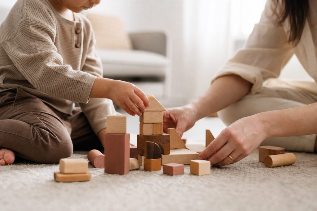 Criança e cuidador brincando com blocos de madeira para estimular o desenvolvimento infantil