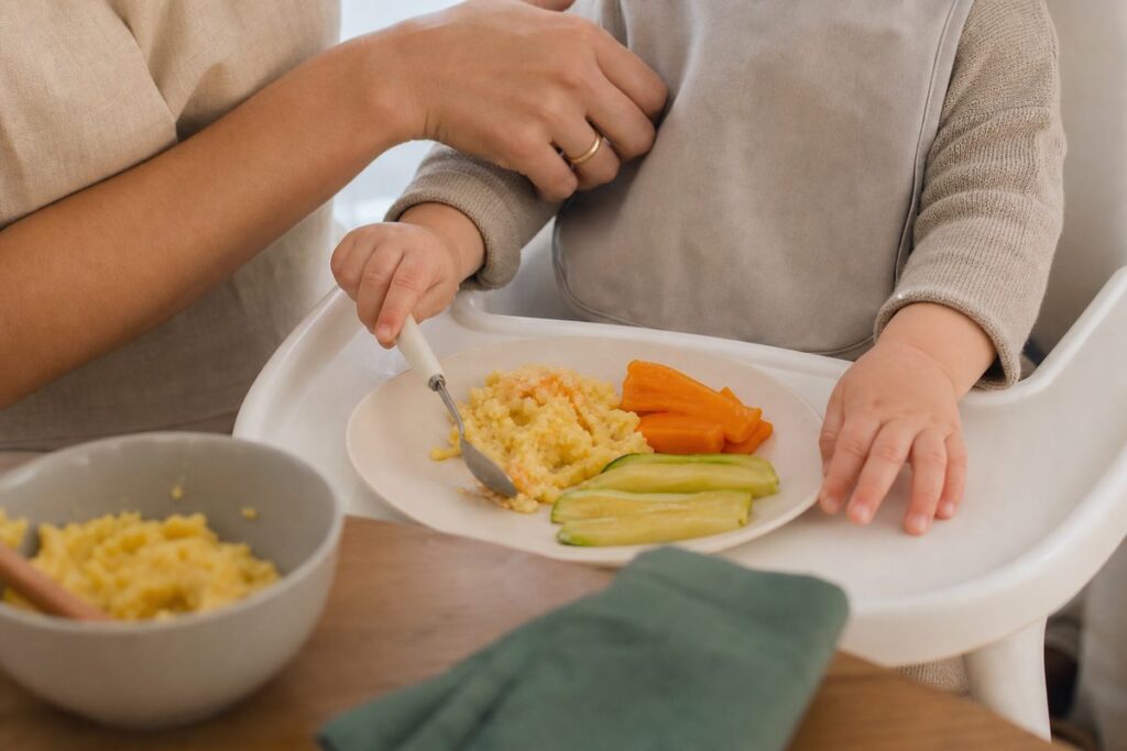 Cuidador supervisionando uma criança durante uma refeição com alimentos macios